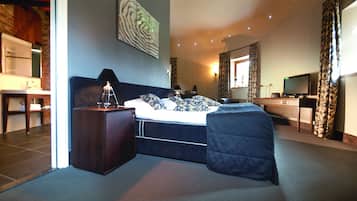 Un dormitorio con cama, mesita de noche, lámpara y cómoda.