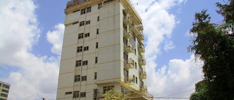 A tall, multi-story building with balconies and a sign indicating it is a hotel.