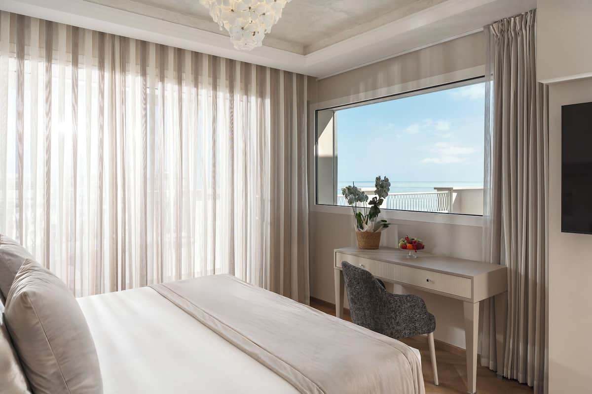 Suite superior, vista al mar | Minibar, caja de seguridad en la habitación y escritorio