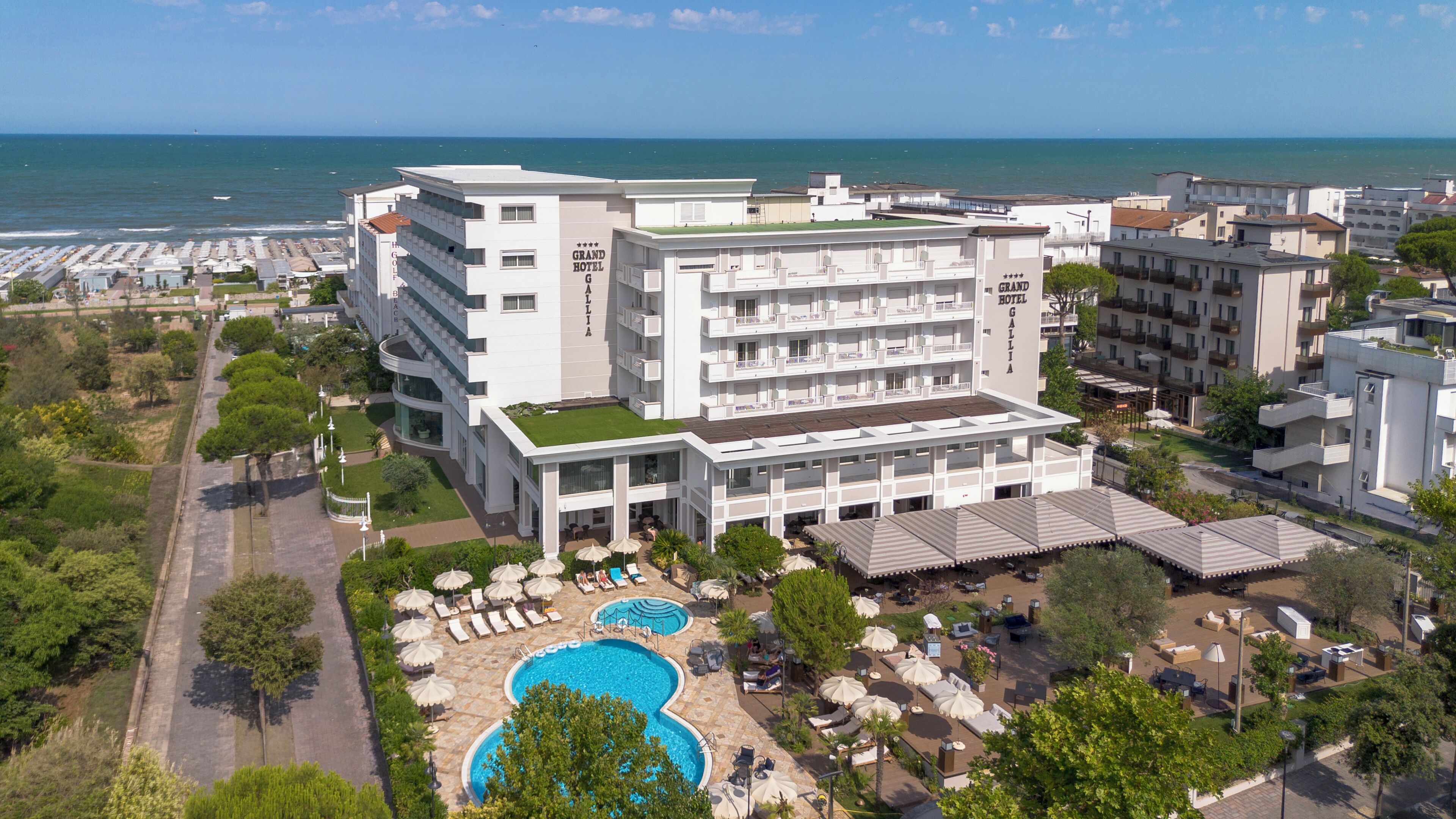 Un hôtel à étages, doté d’une piscine et offrant une vue sur la mer.