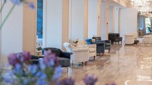 A spacious lobby with a chandelier, seating areas, and a polished floor. - Grand Hotel Gallia (Cervia)