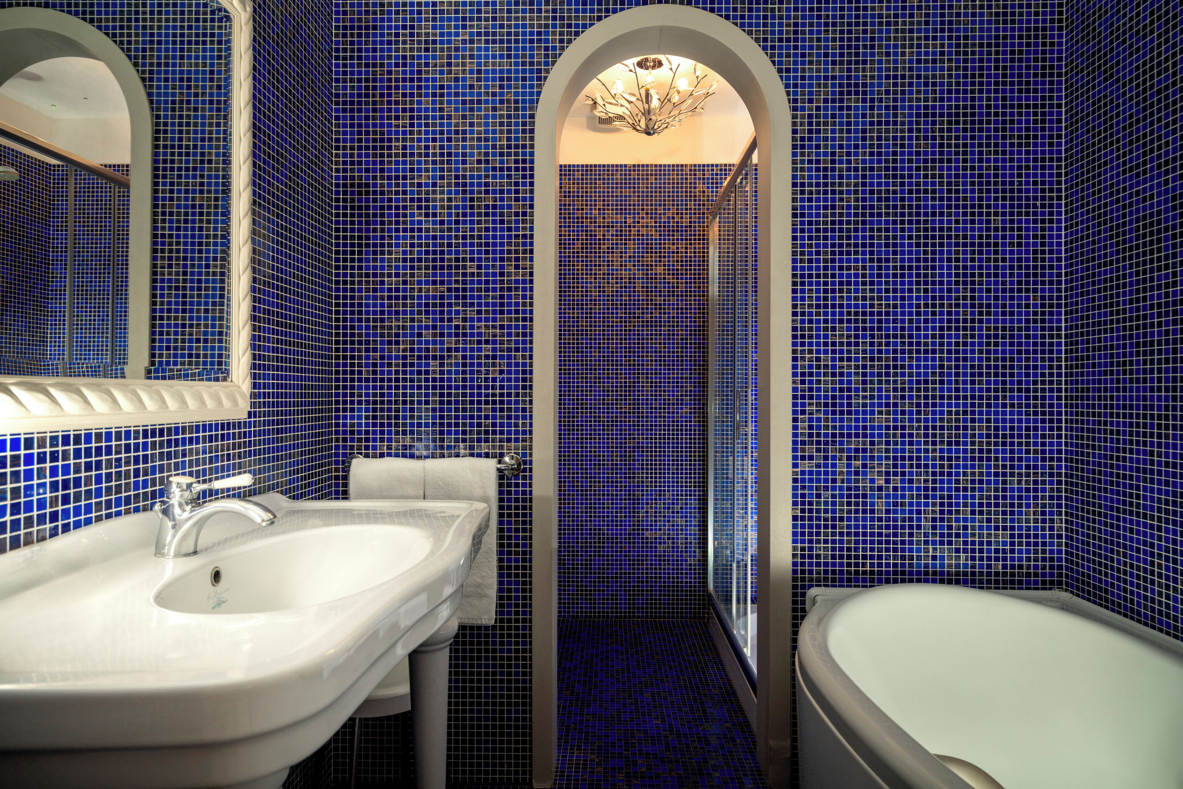 Ein Badezimmer mit einem weißen Waschbecken, einem Spiegel und einer Badewanne.