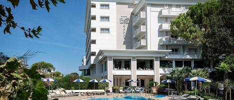 Alberca al aire libre, sombrillas en la alberca y camastros