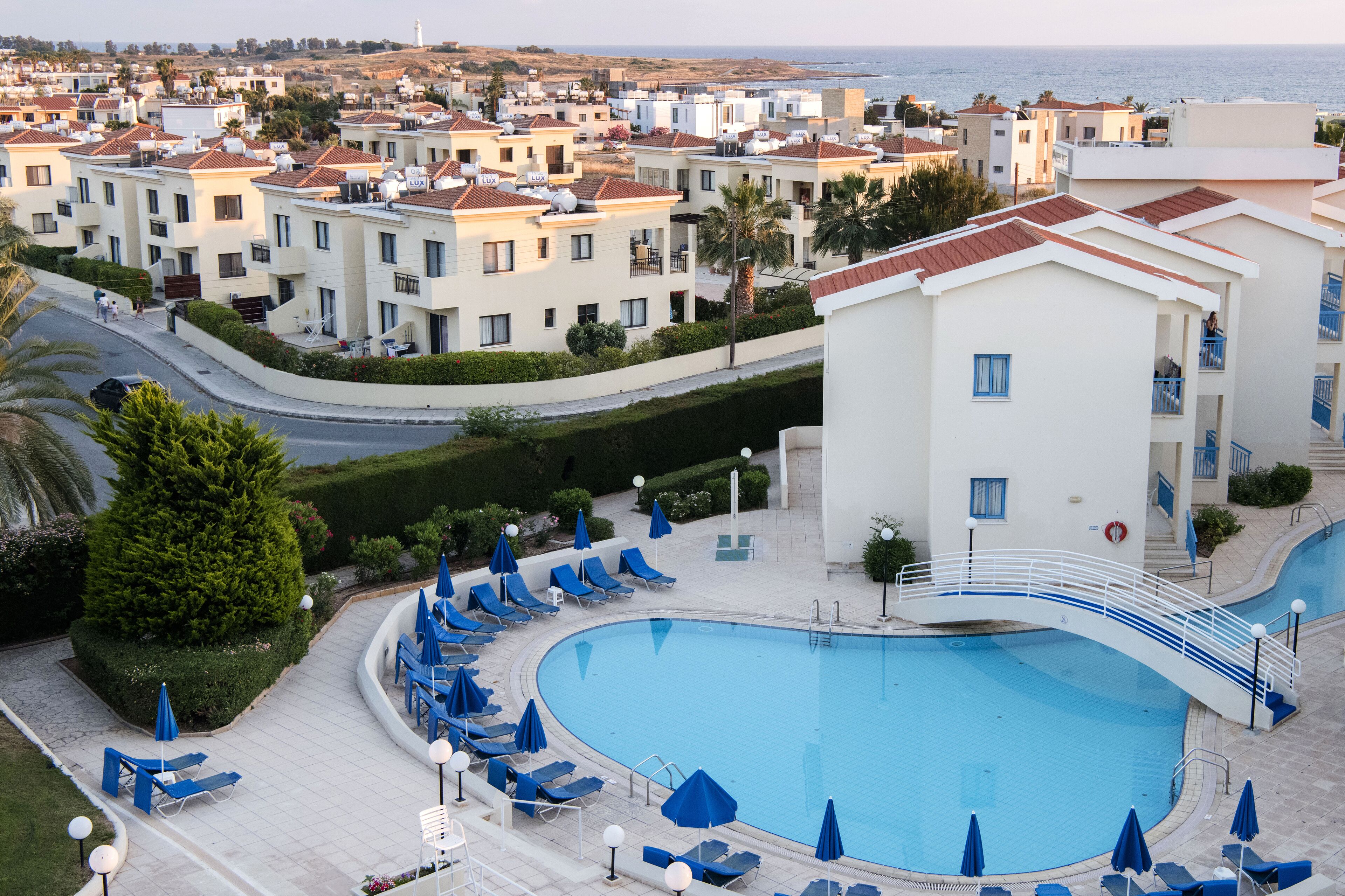 Um resort com piscina, espreguiçadeiras e vista para o mar.