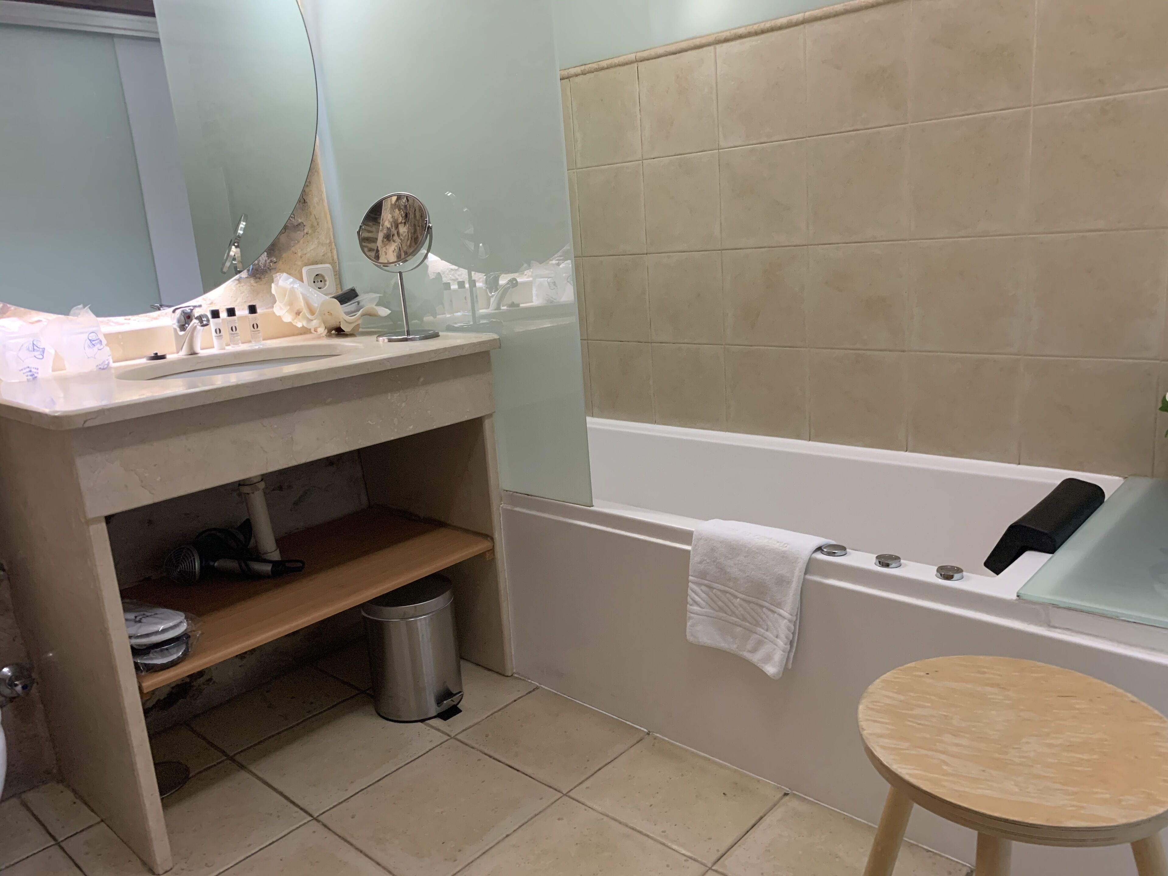 A bathroom with a sink, mirror, and bathtub.