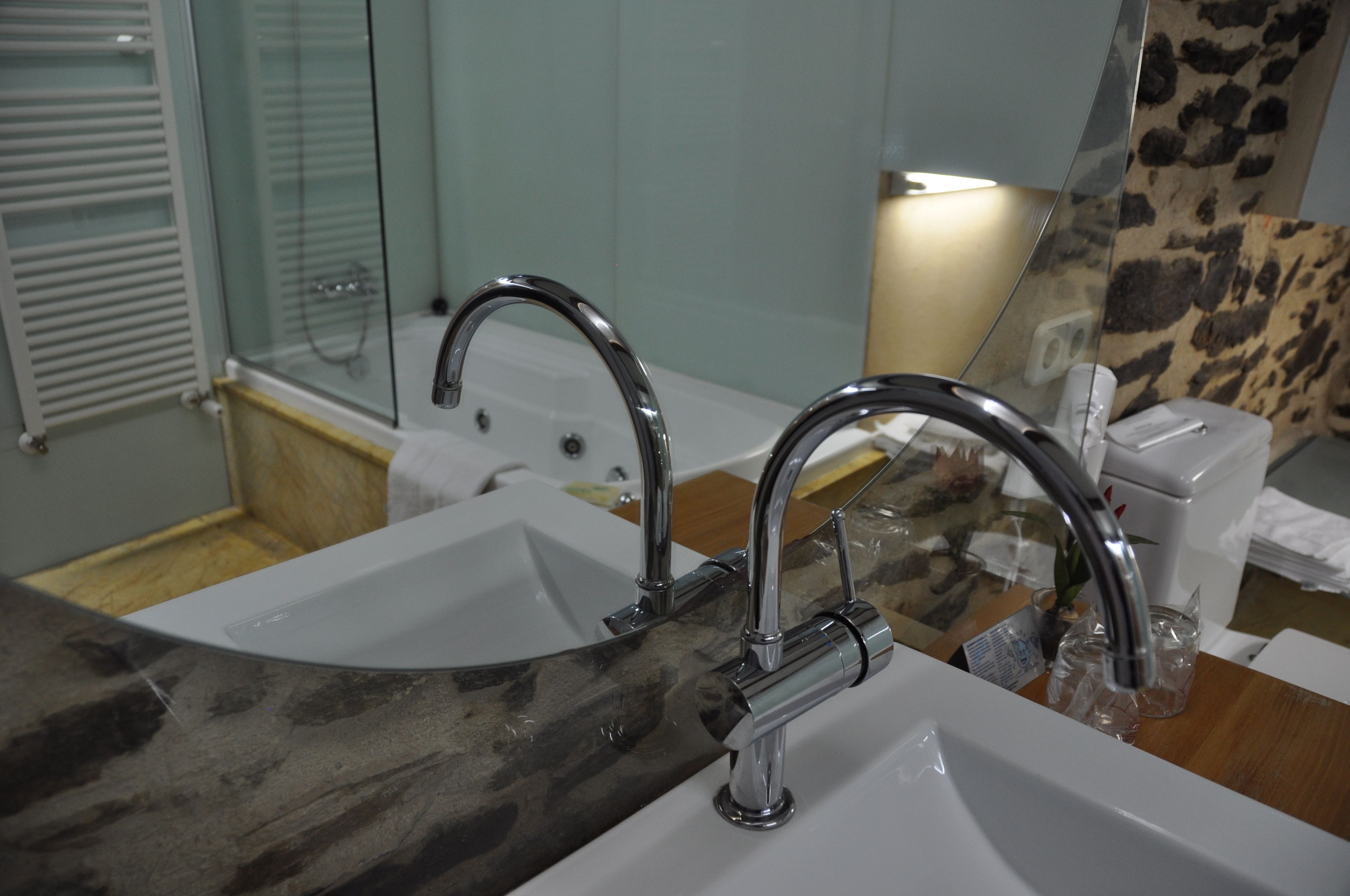 A bathroom with a sink, mirror, and a towel rack.