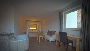 Un salon moderne avec une cheminée en pierre, un bureau en bois, un canapé confortable et une grande fenêtre avec des rideaux.
