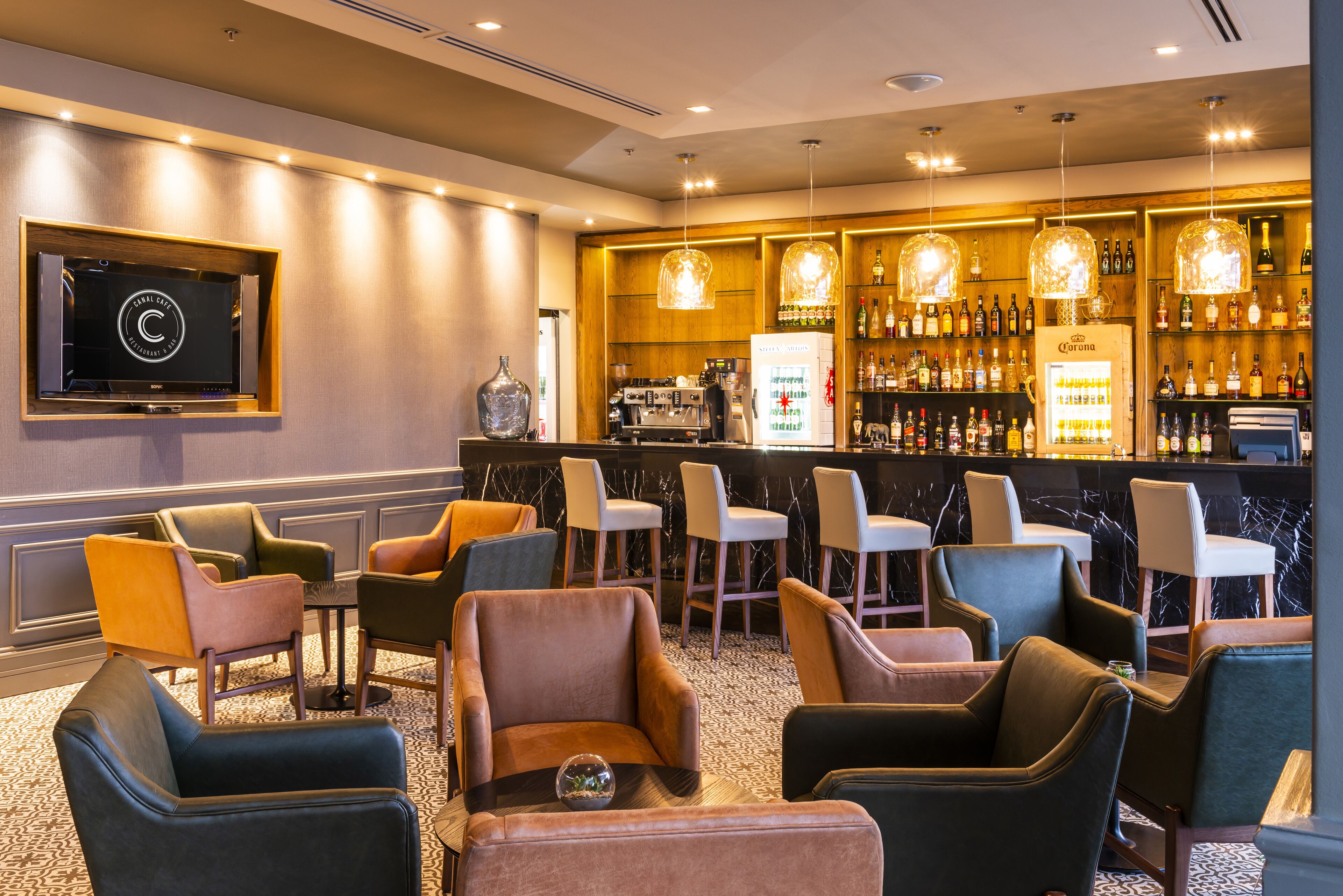 Eine Bar mit Sitzgelegenheiten und einem Fernseher.