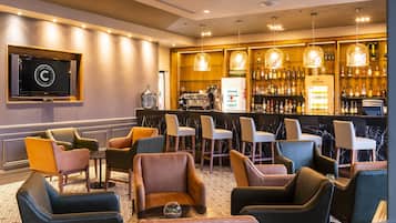 Eine Bar mit Sitzgelegenheiten und einem Fernseher.