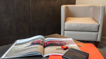 Una revista con un automóvil en la portada, una billetera y un par de gafas sobre una mesa.