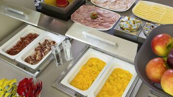 Ein Buffet mit verschiedenen Speisen, darunter Fleisch, Obst und Soßen.