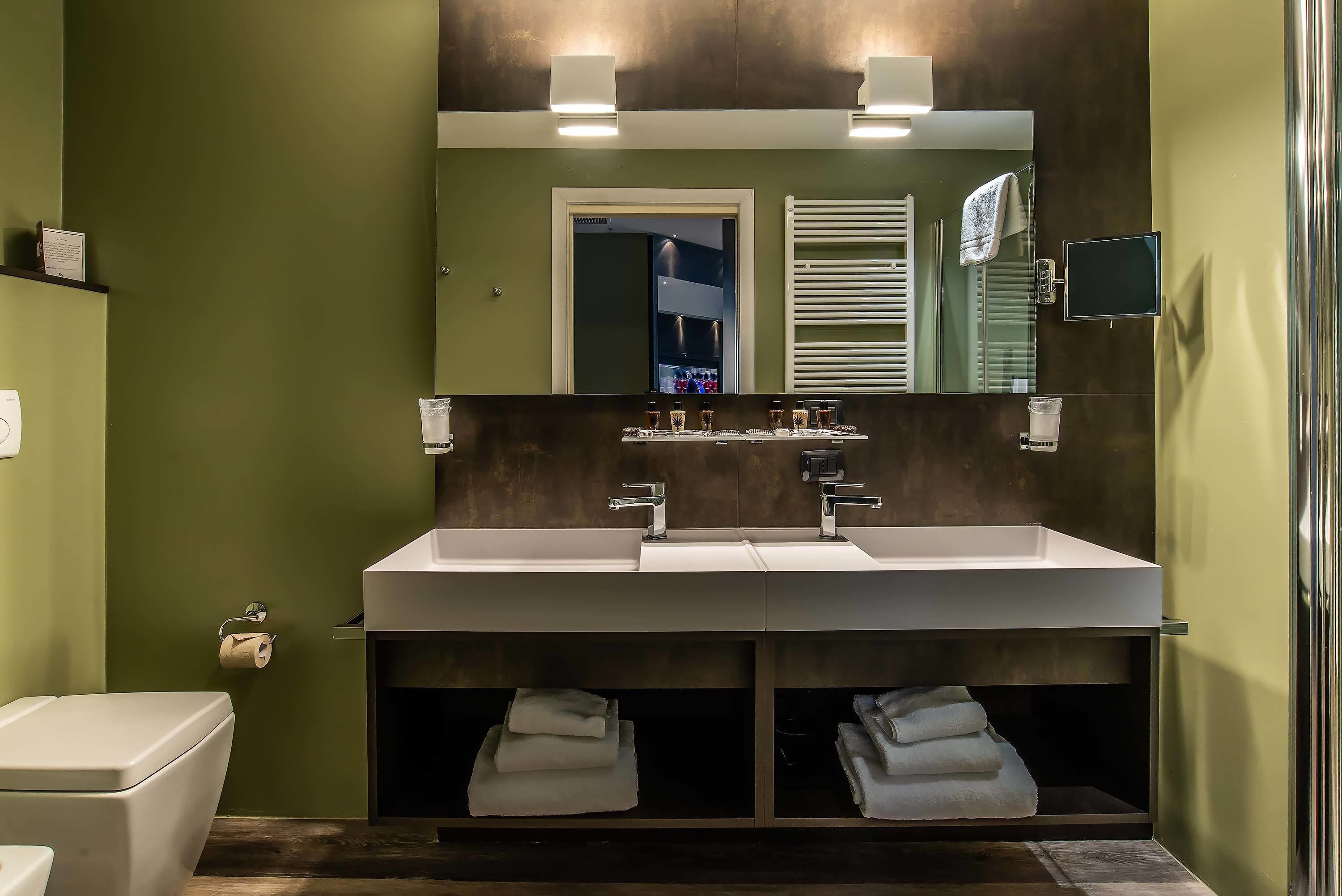 A modern bathroom with a large sink, a toilet, and a mirror.