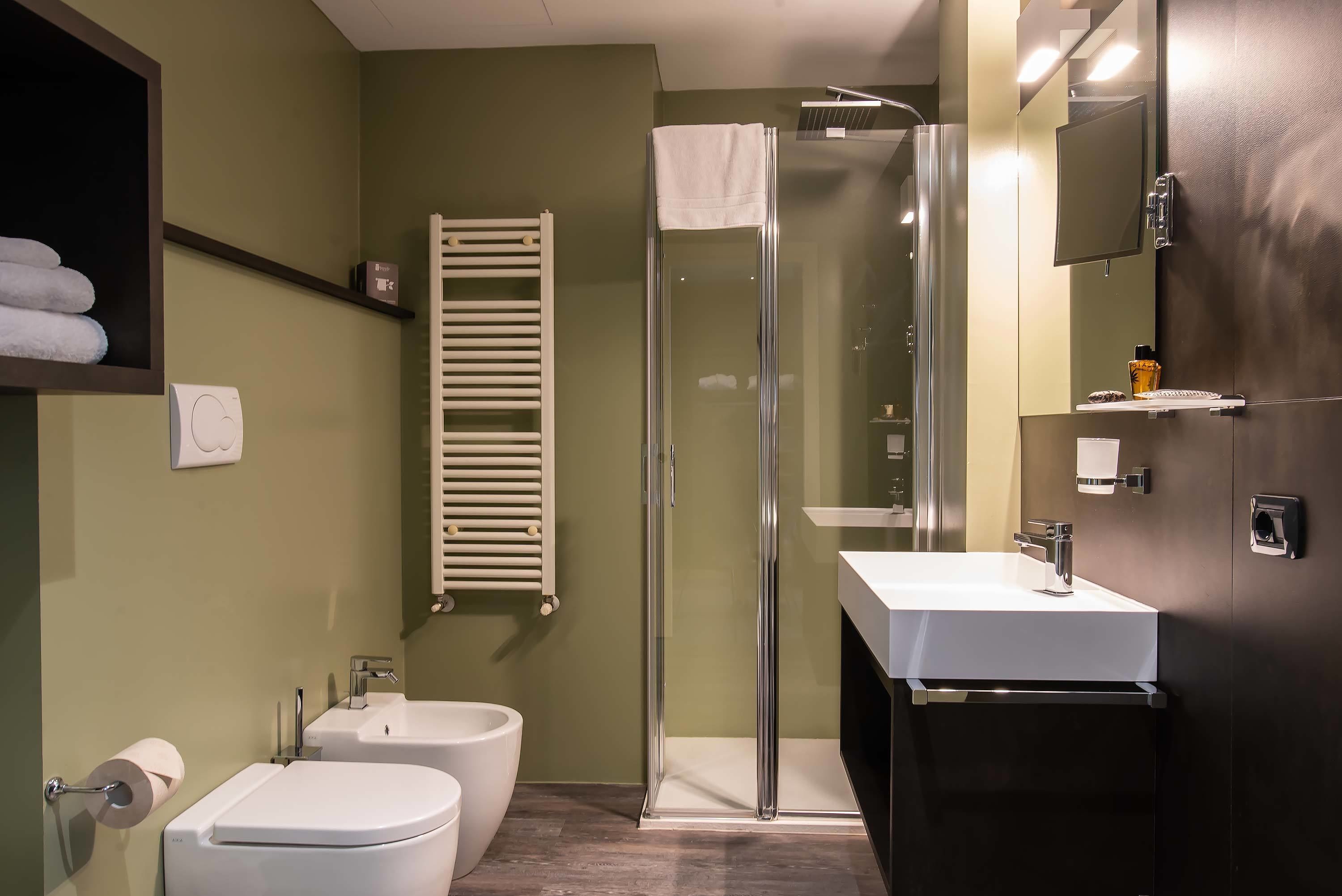 A modern bathroom with a glass-enclosed shower, a white sink, and a toilet.