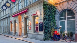 Un bâtiment historique, reconnaissable à son imposante enseigne « HÔTEL CASATI », à ses grandes fenêtres et à un vélo garé devant.