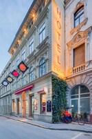 A historic building with a prominent "HOTEL CASATI" sign, large windows, and a bicycle parked outside.