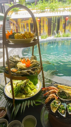 Enjoy a poolside buffet featuring a variety of seafood and vegetables.