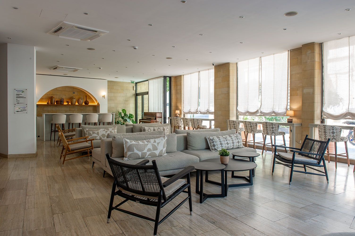 A spacious lounge area with seating arrangements, a fireplace, and large windows providing natural light.