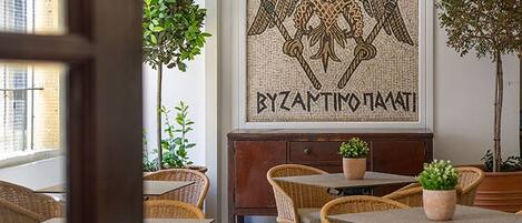 Un intérieur agrémenté de meubles en osier, d’une œuvre d’art murale en mosaïque et de plantes en pot.