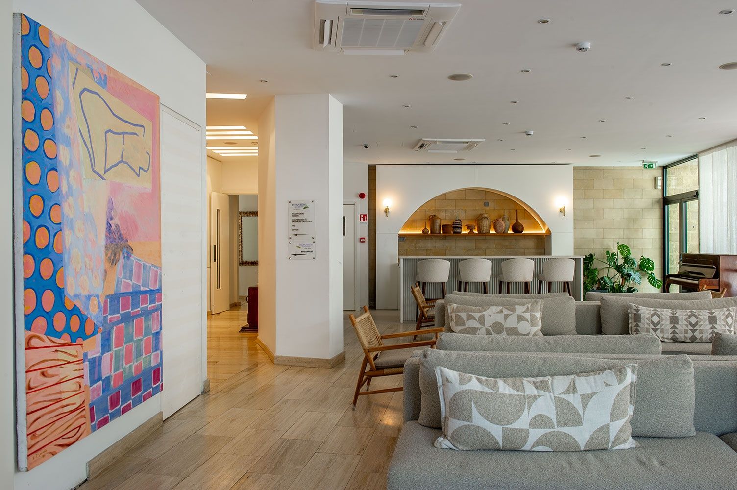 A modern interior with a seating area, a fireplace, and a large abstract painting.