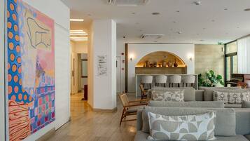 A modern interior with a seating area, a fireplace, and a large abstract painting.