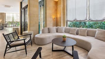 A modern living room with a sectional sofa, a round coffee table, and a black chair.