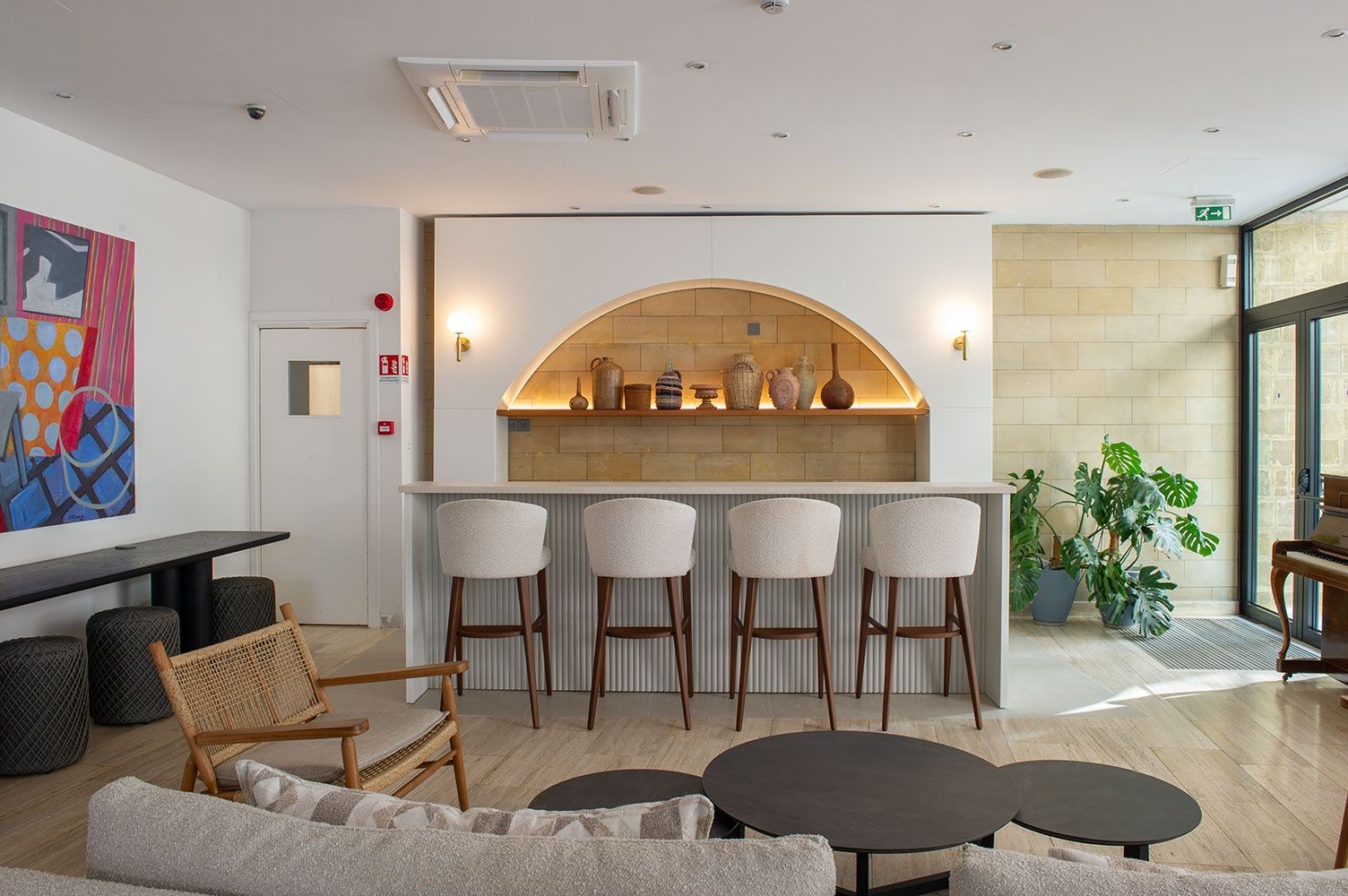A modern lounge area with a bar, seating, and a piano.