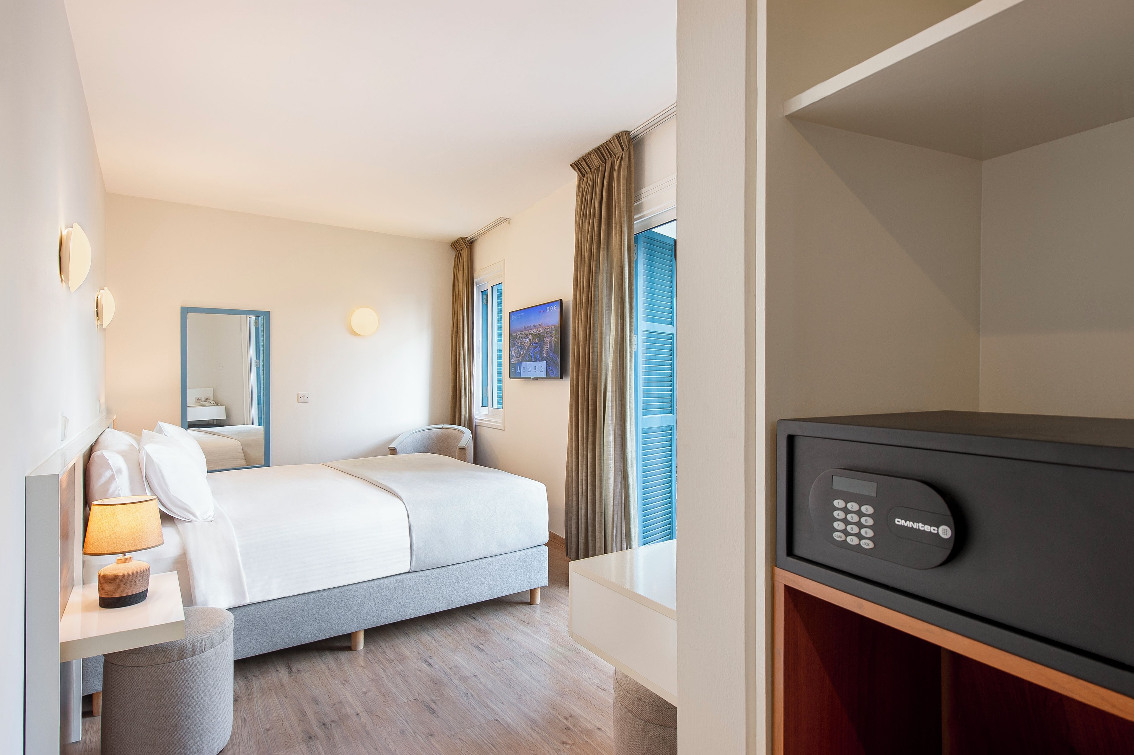 Une chambre d’hôtel équipée d’un lit, d’une table de chevet, d’une lampe et d’un téléviseur.