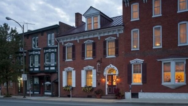 A row of brick buildings with large windows and a central building with a prominent entrance. - Carlisle House (Carlisle)