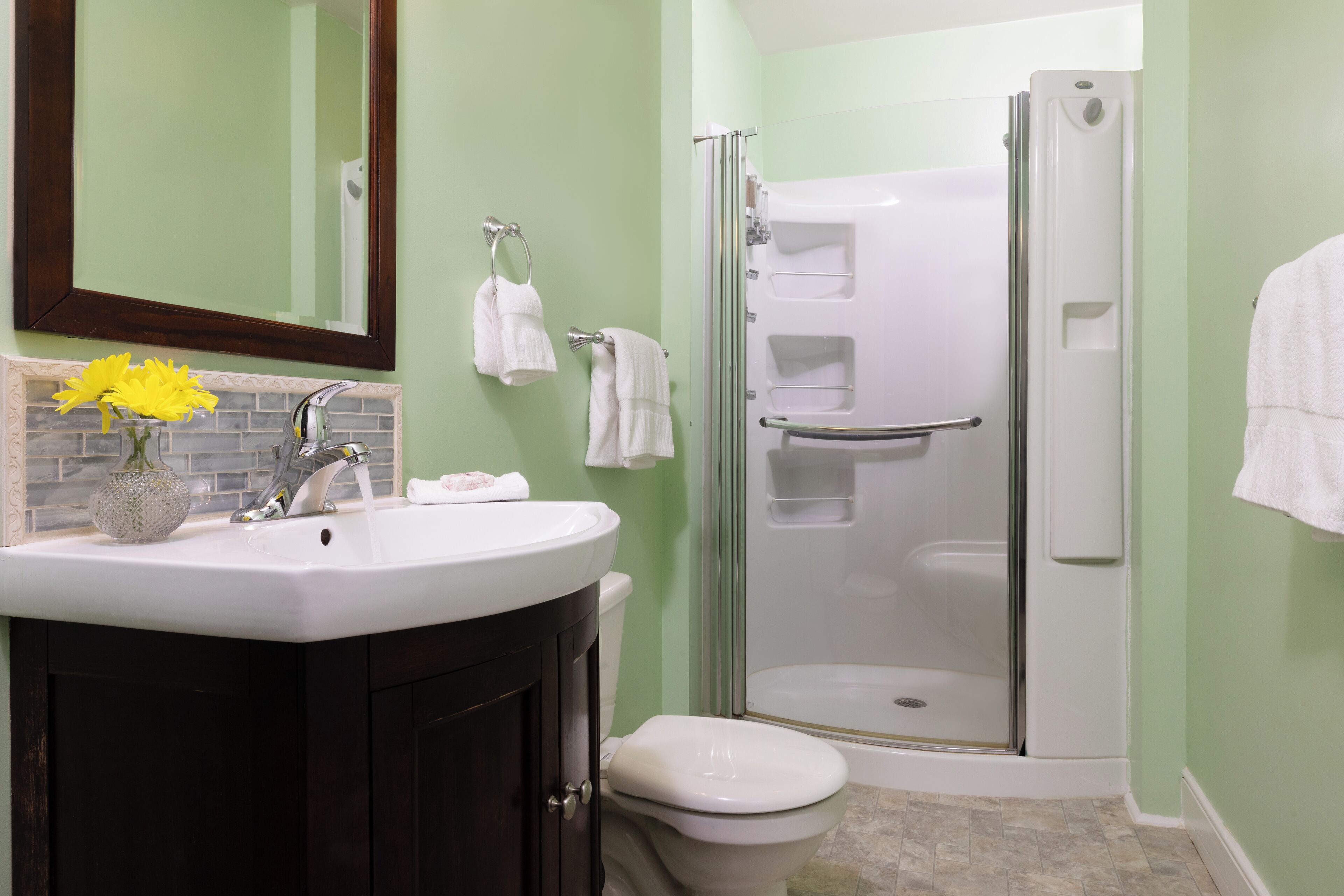 Un bagno con lavandino, specchio, servizi igienici e doccia vetrata.