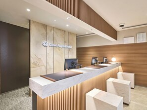 A hotel reception desk with a marble counter, wooden paneling, and a sign for Daiwa Roynet Hotel. - Daiwa Roynet Hotel Nagoya Station (Renewal Open in May 2026) (Nagoya)