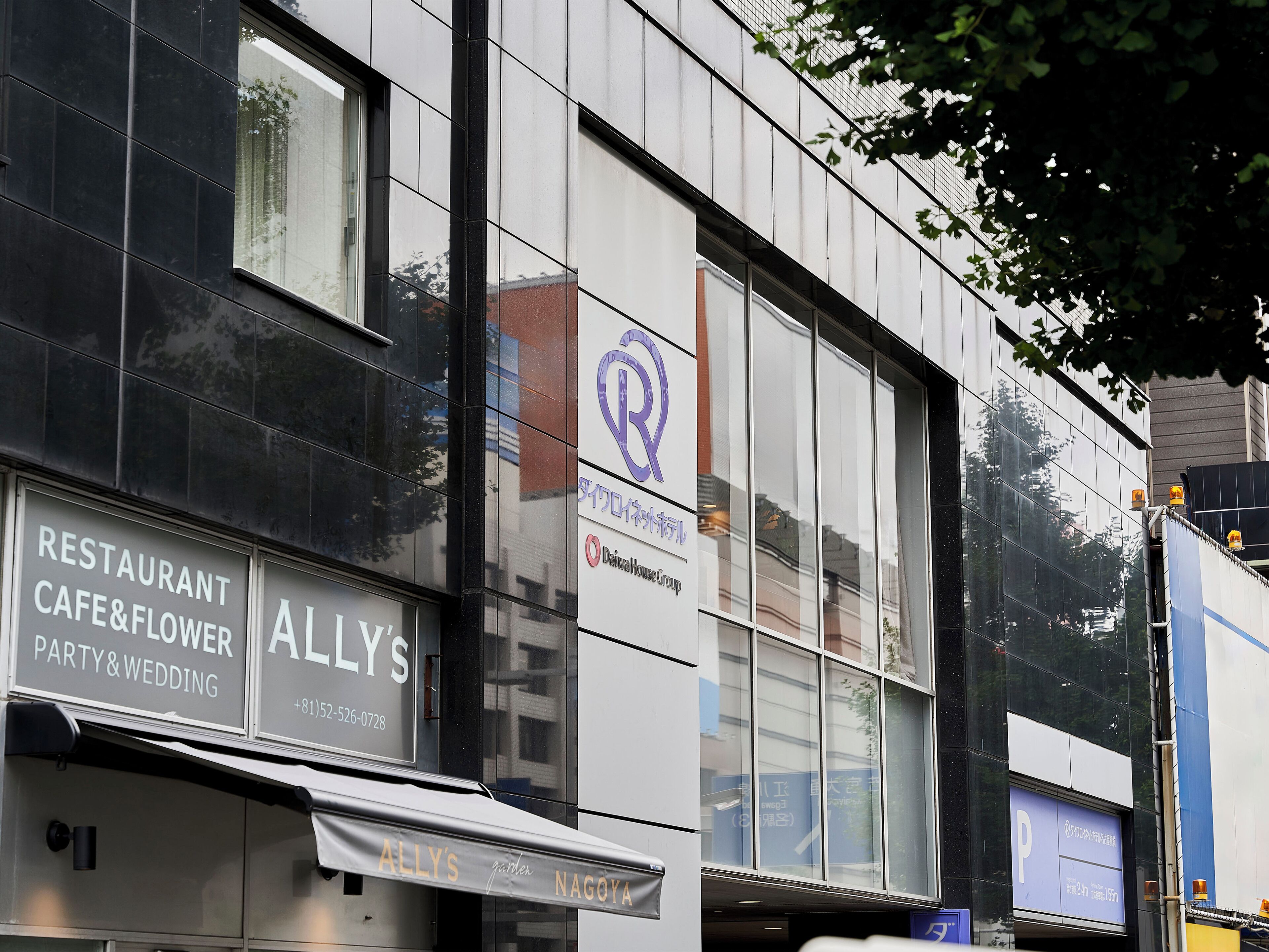 A building with a restaurant named "Allly's" and a sign for "Daisuke House Group".