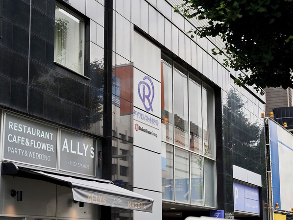 A building with a restaurant named "Allly's" and a sign for "Daisuke House Group".