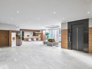A modern hotel lobby with a reception desk, seating area, and a large elevator. - Daiwa Roynet Hotel Nagoya Station (Renewal Open in May 2026) (Nagoya)