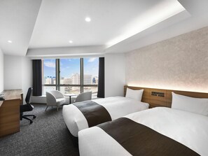 A hotel room with two beds, a desk, a chair, and a view of the city. - Daiwa Roynet Hotel Nagoya Station (Renewal Open in May 2026) (Nagoya)