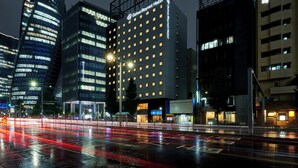 Un hotel Daiwa Royal dal design moderno, con una segnaletica ben visibile e numerose finestre illuminate.