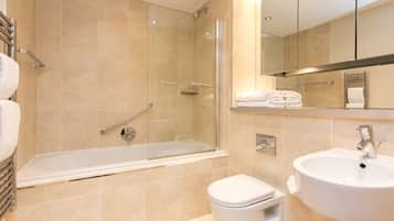 A modern bathroom with a bathtub, toilet, and sink.