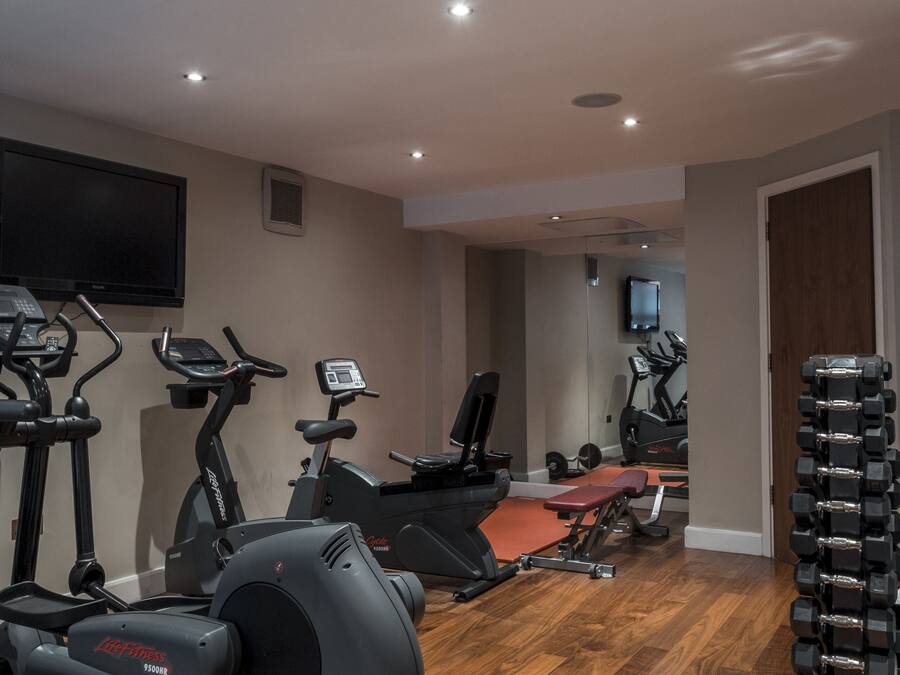 A home gym with exercise equipment, a television, and a mirror.