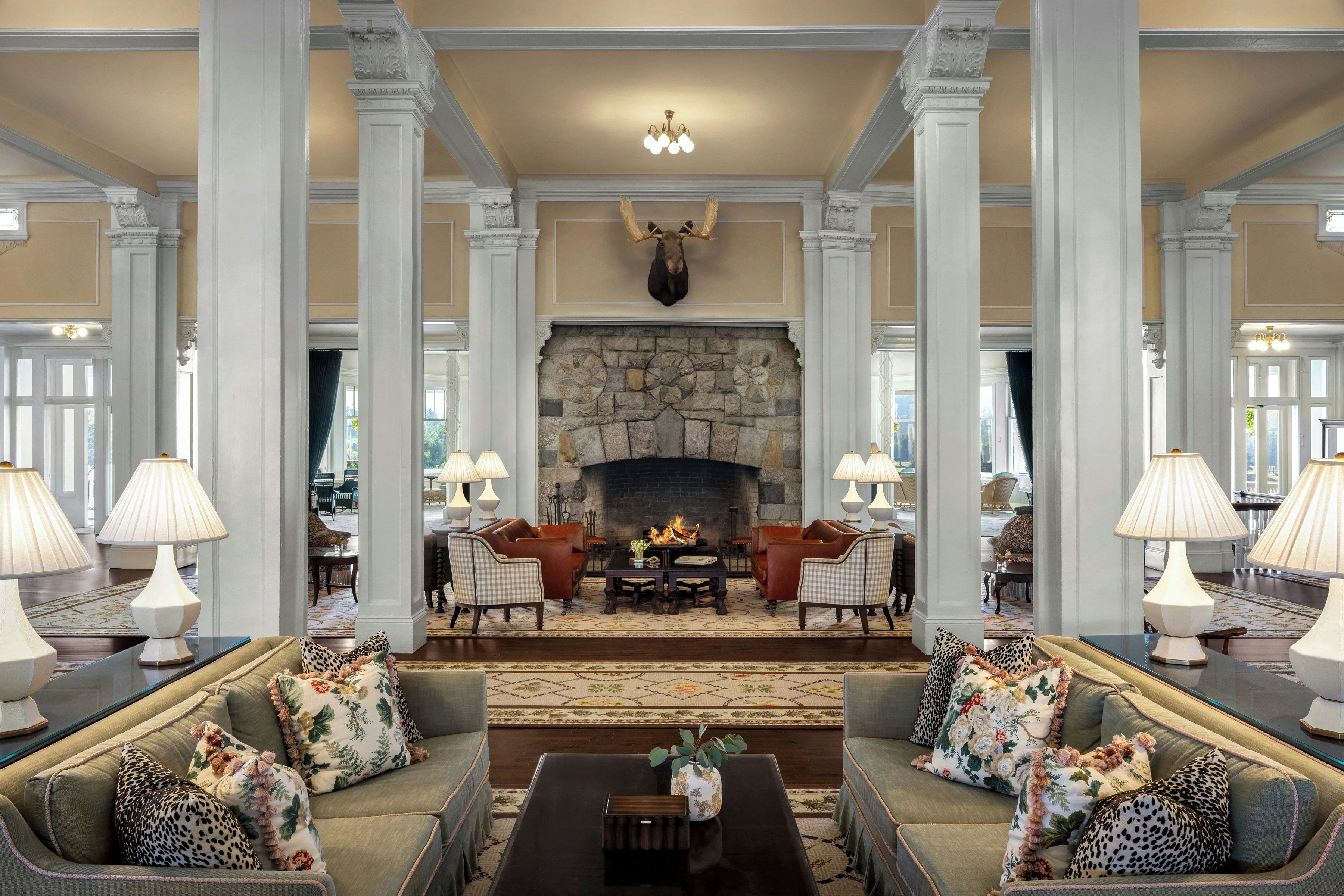 A spacious lobby with a stone fireplace, leather sofas, and a chandelier.