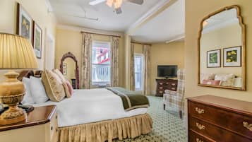 Une chambre d’hôtel avec un lit, une commode, un miroir et un téléviseur.
