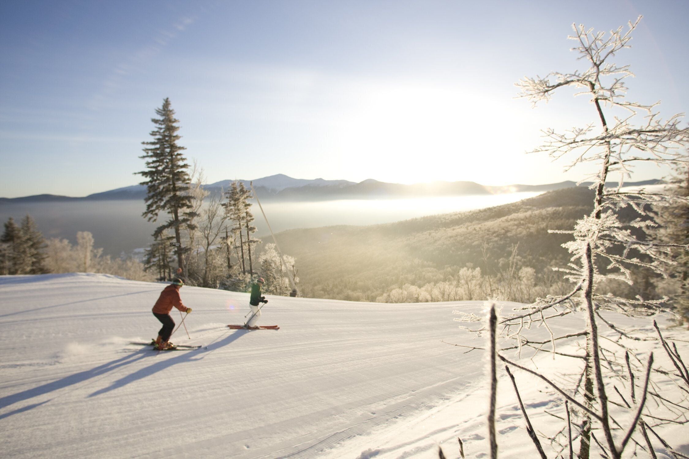 A snowy ski slope with a person skiing.