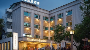 A hotel with a modern facade, large windows, and a sign indicating it is a Grand Pleasure Spring Hotel. - Grand Pleasure Spring Hotel (Taipei)