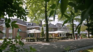 A hotel with outdoor seating, a parking sign, and a well-maintained garden area. - Boshotel Vlodrop (Vlodrop)