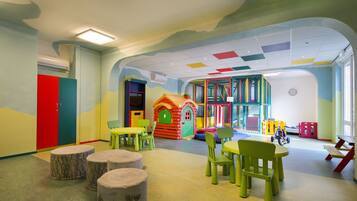 Children can play and socialize in this vibrant play area featuring a playhouse, slide, and climbing frames.