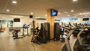 A gym with cardio machines, weightlifting equipment, and a TV screen. - Boshotel Vlodrop (Vlodrop)