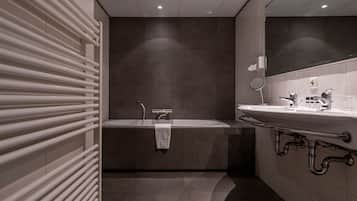 A modern bathroom with a bathtub, a sink, and a mirror.