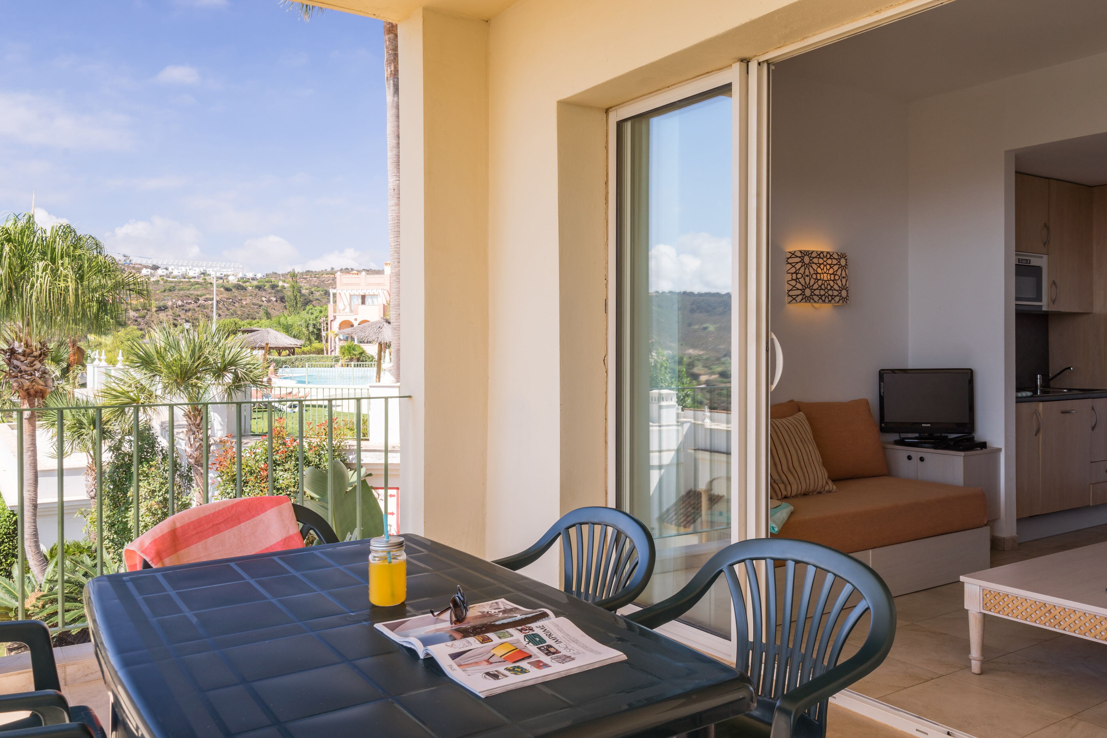 A balcony with a table, chairs, and a sofa.