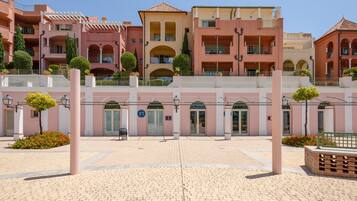 Un hotel de varios pisos con balcones, un patio central y piso de baldosas.