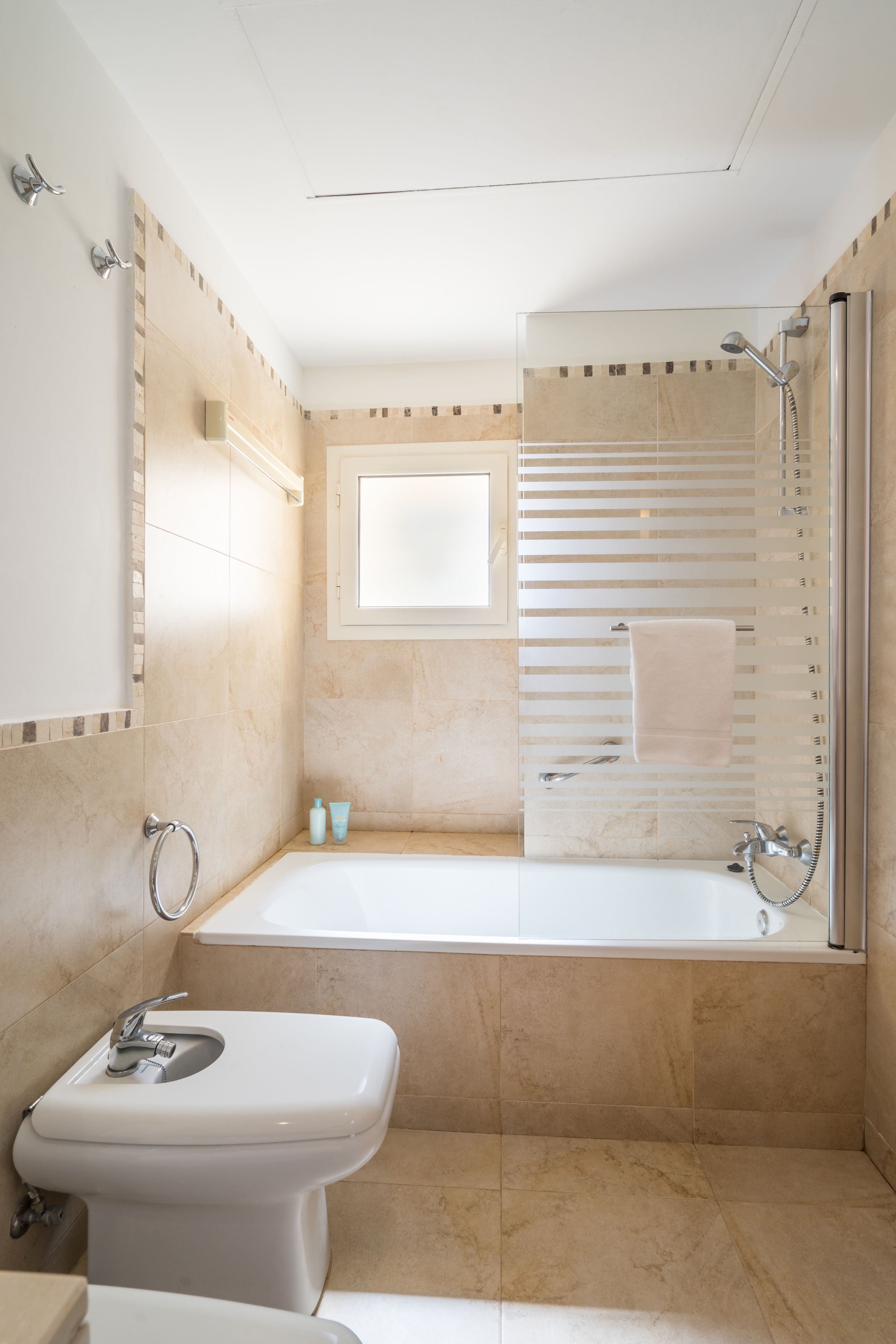 Een moderne badkamer met een bad, toilet en wastafel.