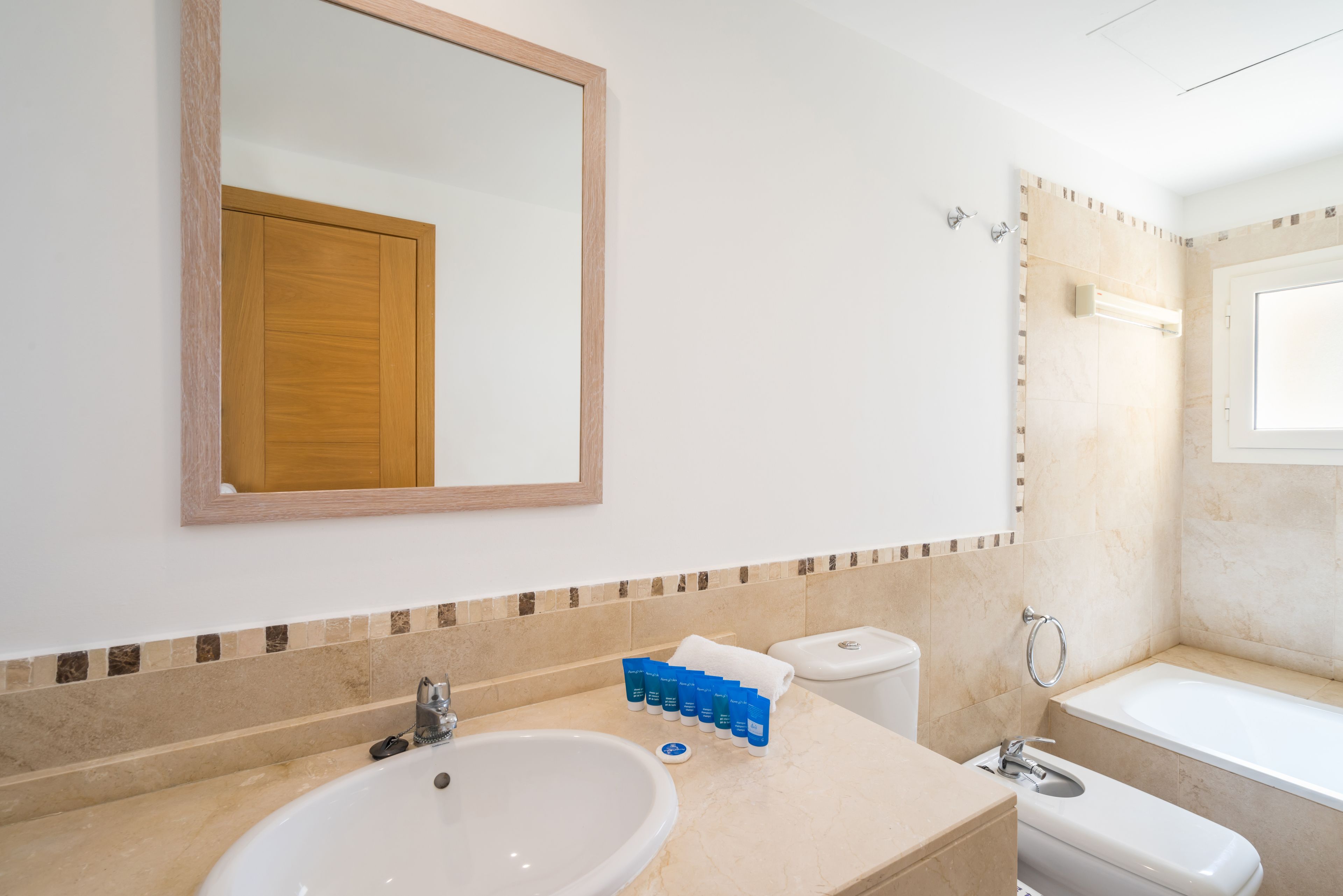 Une salle de bain équipée d’un lavabo, d’un miroir, de toilettes et d’une baignoire.