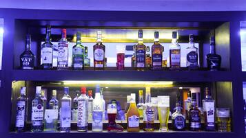 Dos estantes con diferentes botellas de licores y vasos.